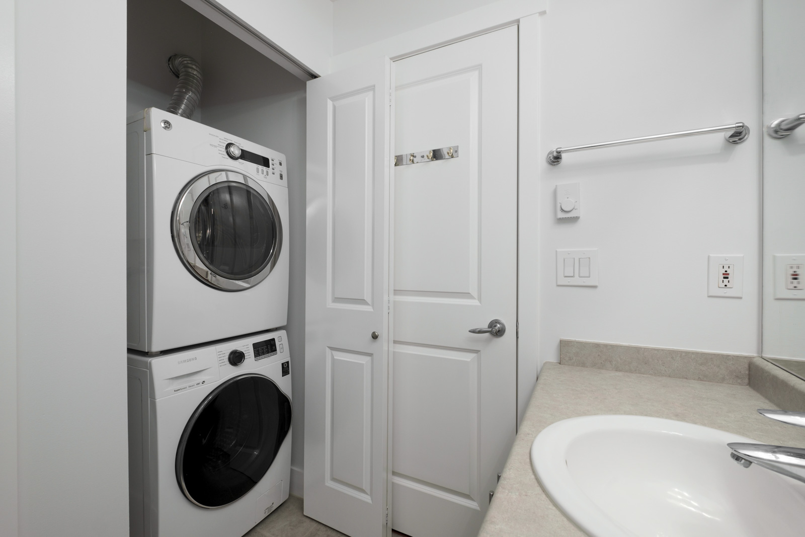 stacked white washer and dryer in closet in rental apartment at alexandra house in shaughnessy of vancouver westside