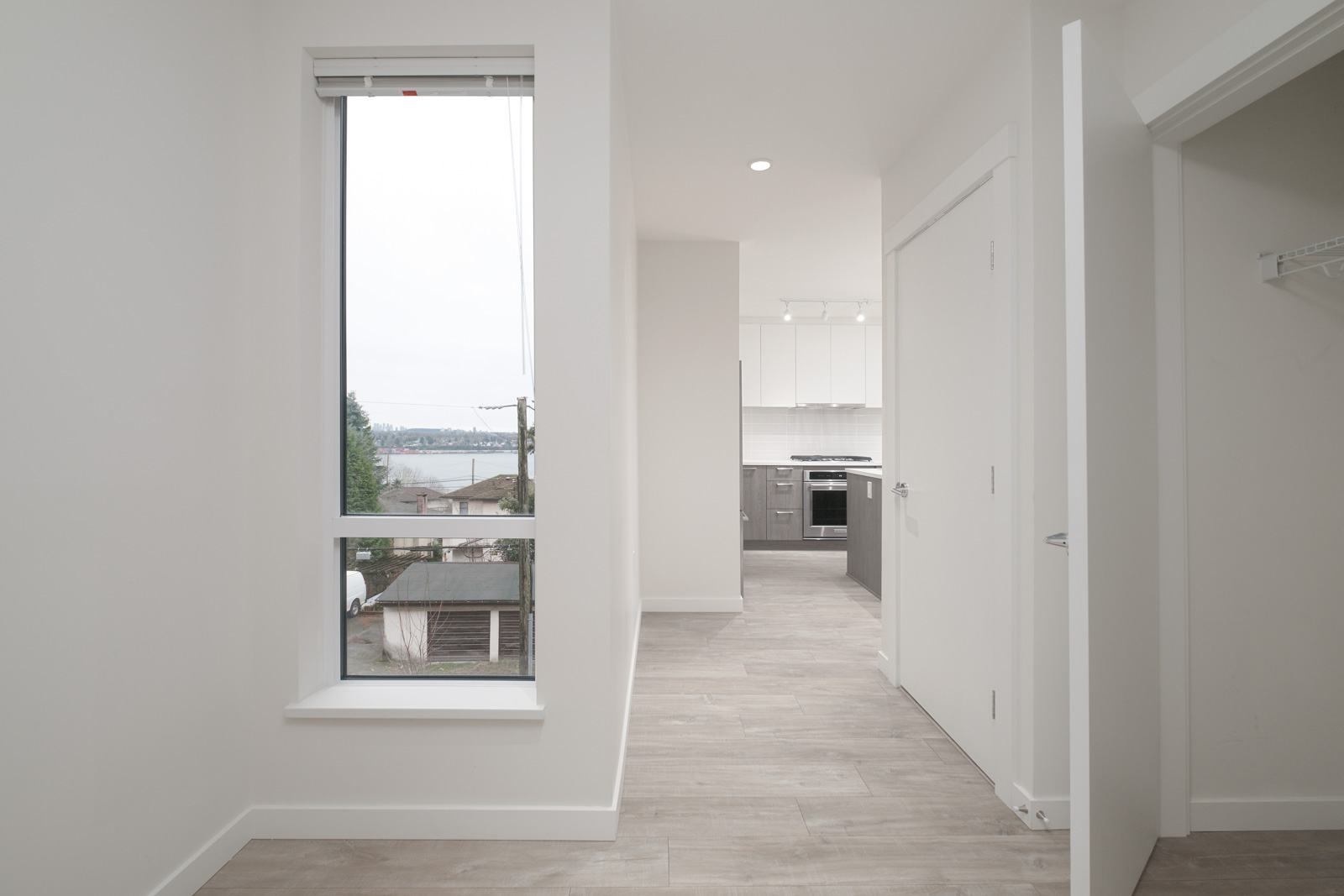 den with white walls and hardwood floors and floor to ceiling windows in rental condo in North Vancouver