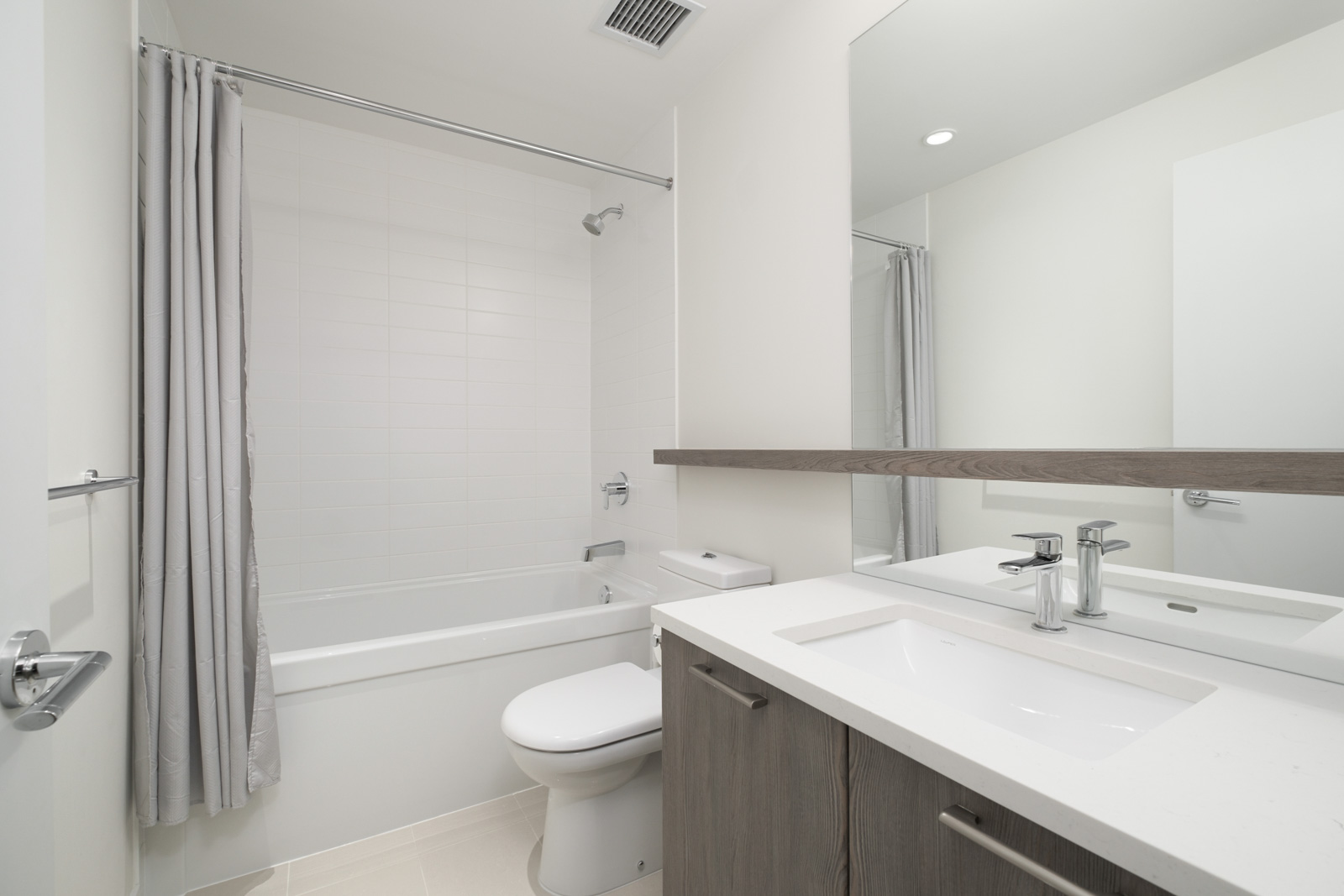 white bathroom with bathtub and huge mirror