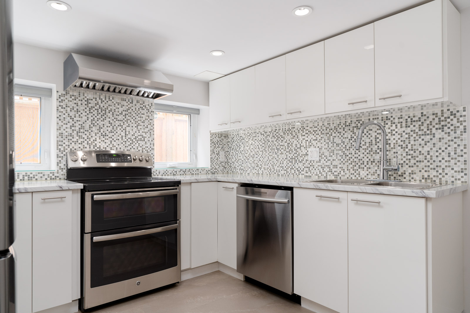 Kitchen equipped with complete stainless steel appliances in home in Vancouver West