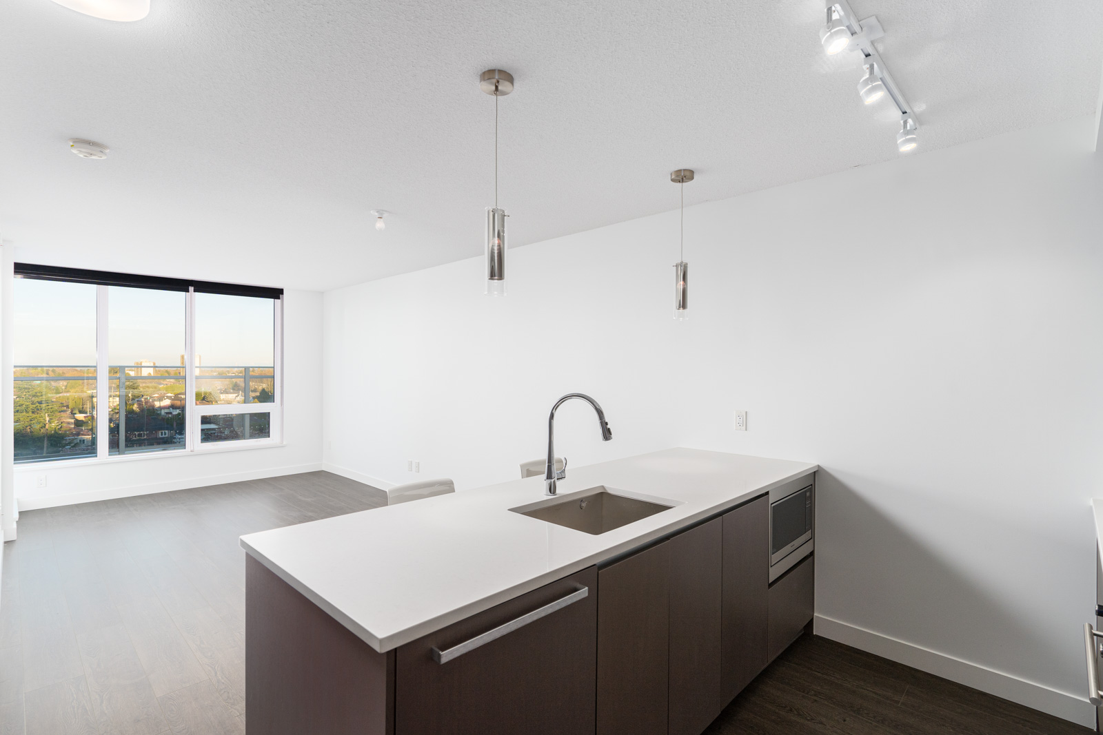 living room and kitchen with white walls and laminate flooring with a floor to ceiling windows in Richmond