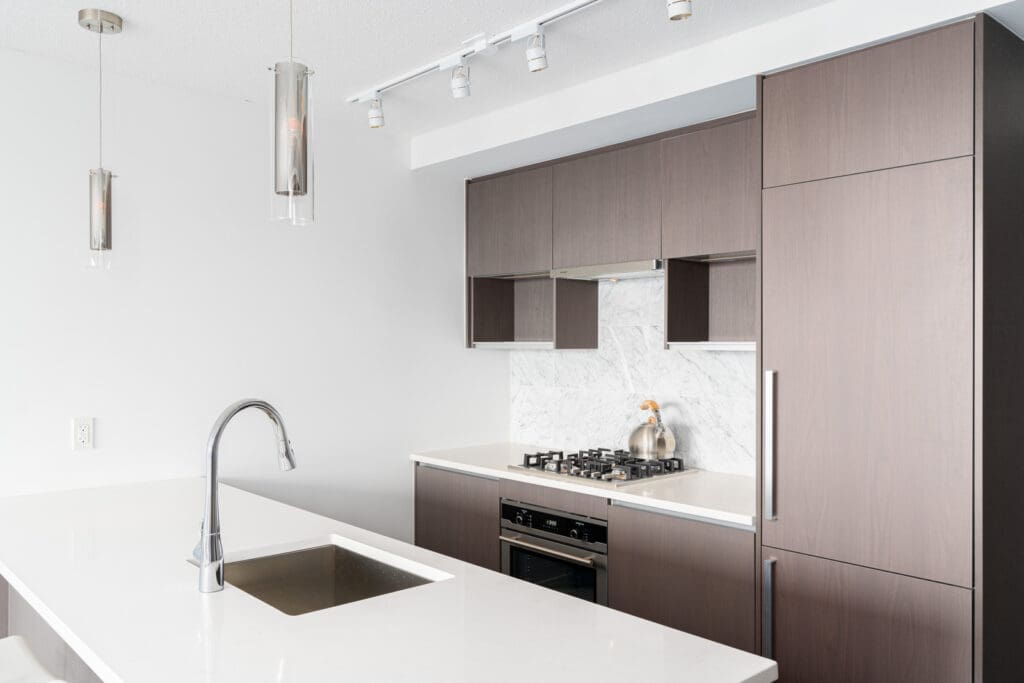 kitchen with stainless steel appliances and brown cabinets in a rental condo in richmond