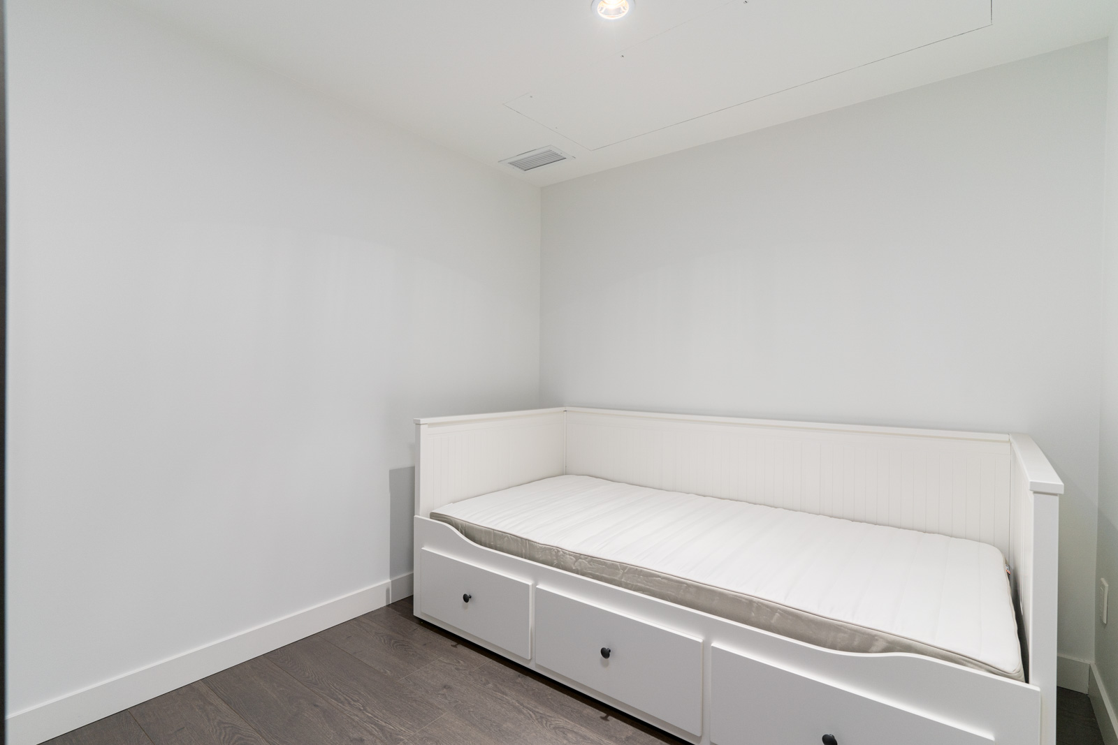 den with white sofa-bed in a room with white walls and with laminate floors