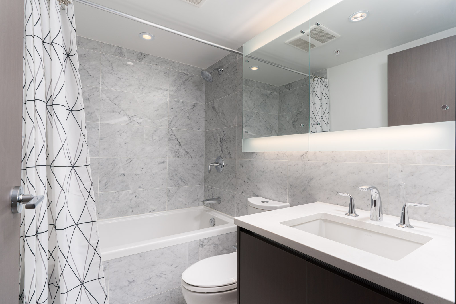 washroom with white sink and a bath tub in a rental condo in richmond