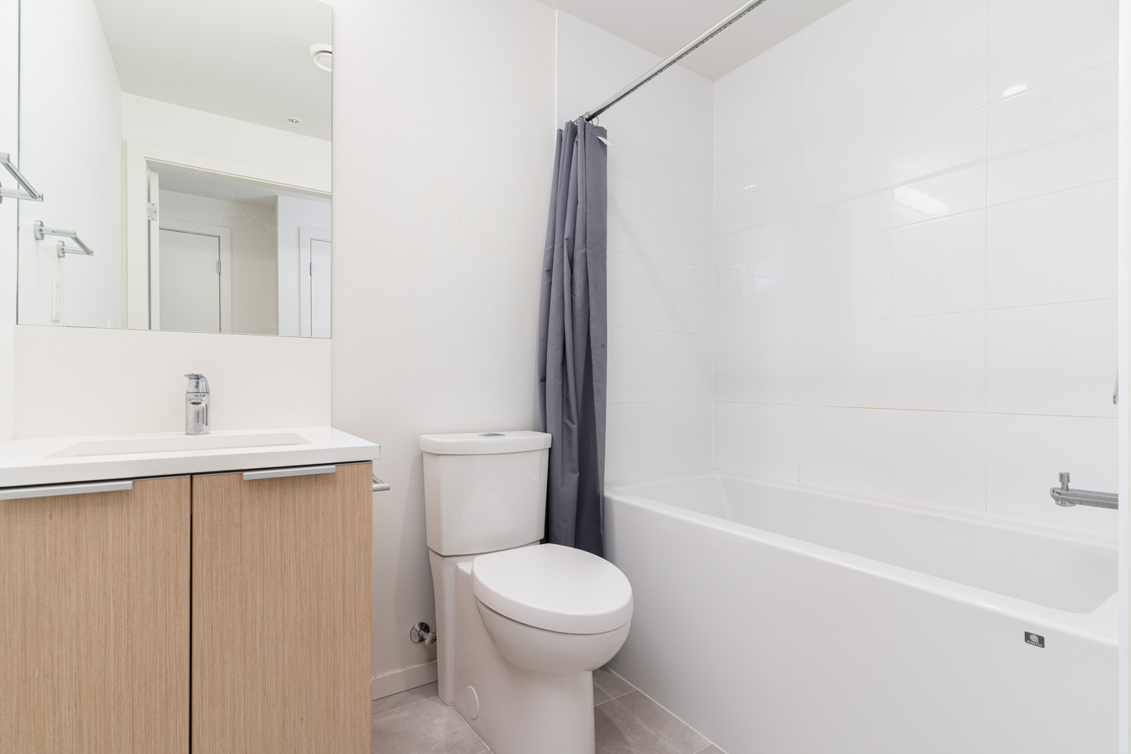 Washroom with bathtub/shower combo, toilet, modern vanity and single sink