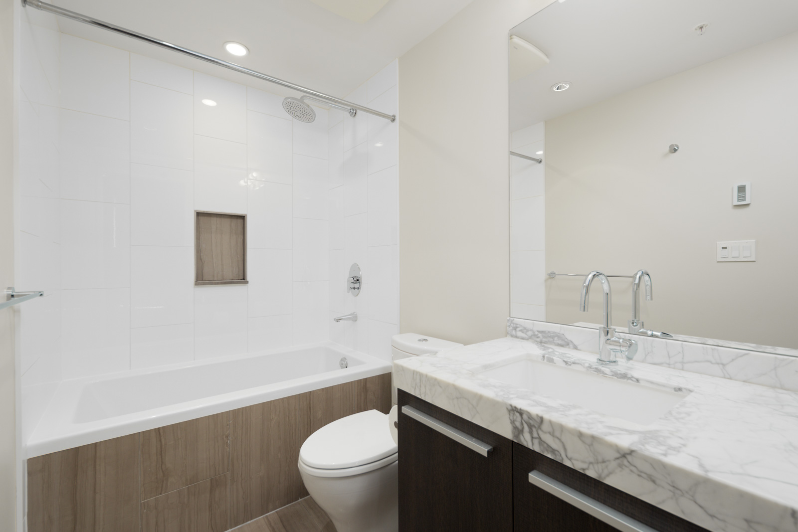 bathroom with white walls and tub