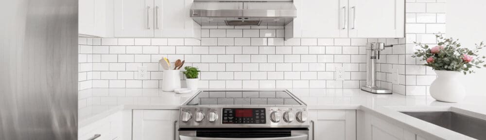 Yaeltown rental condo with white kitchen and fresh pink flowers