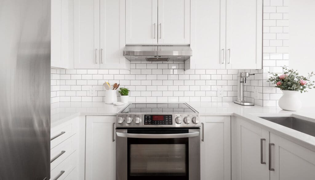Yaeltown rental condo with white kitchen and fresh pink flowers