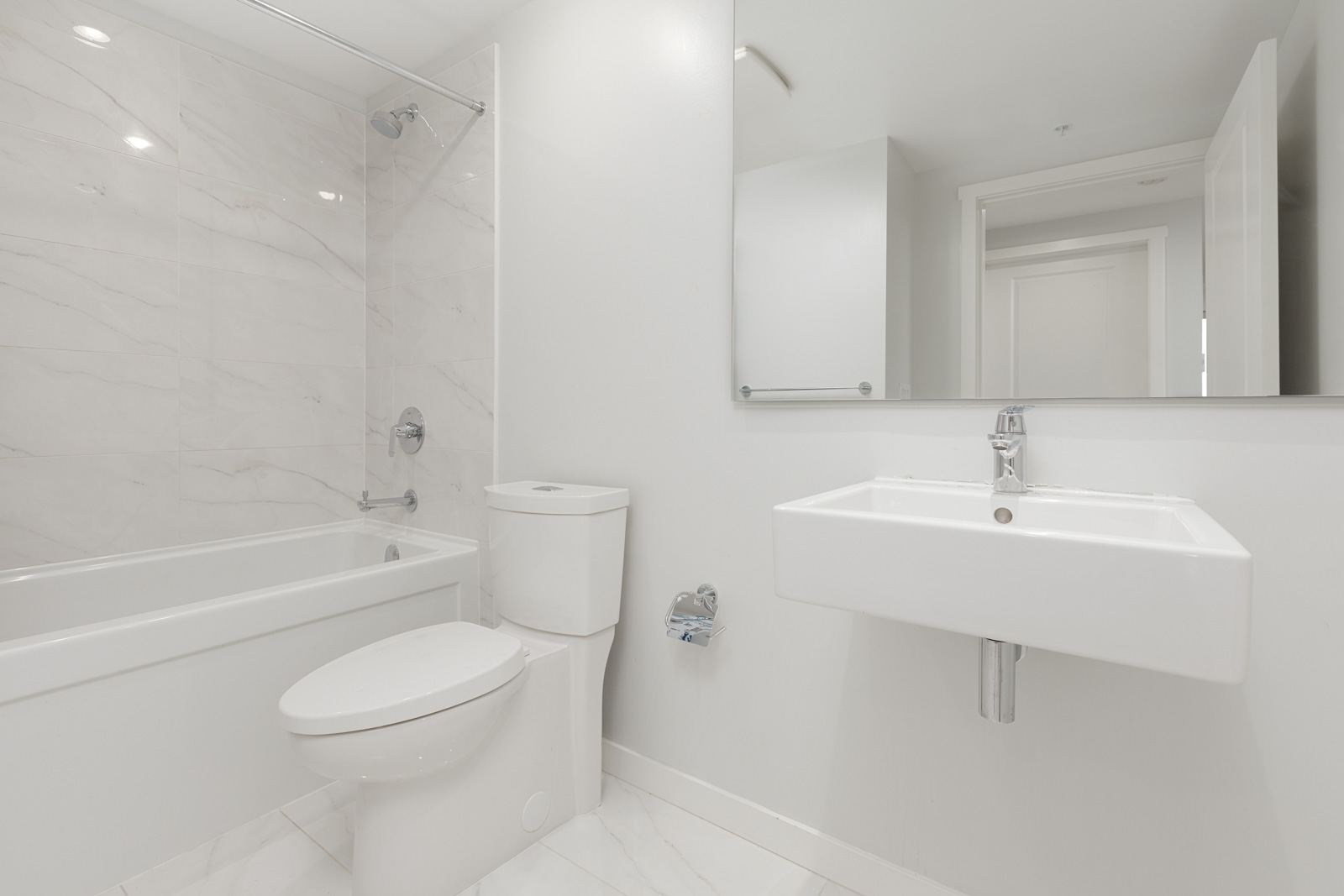 bathroom with toilet, sink, and tub