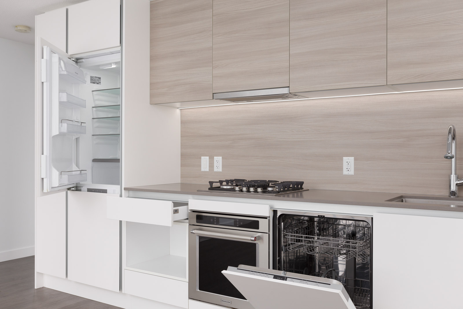 open dishwasher in a white kitchen in a wood parts