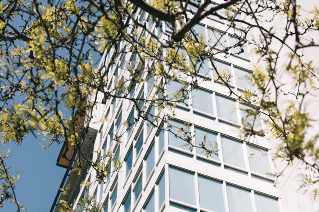High-rise condo with trees in the foreground