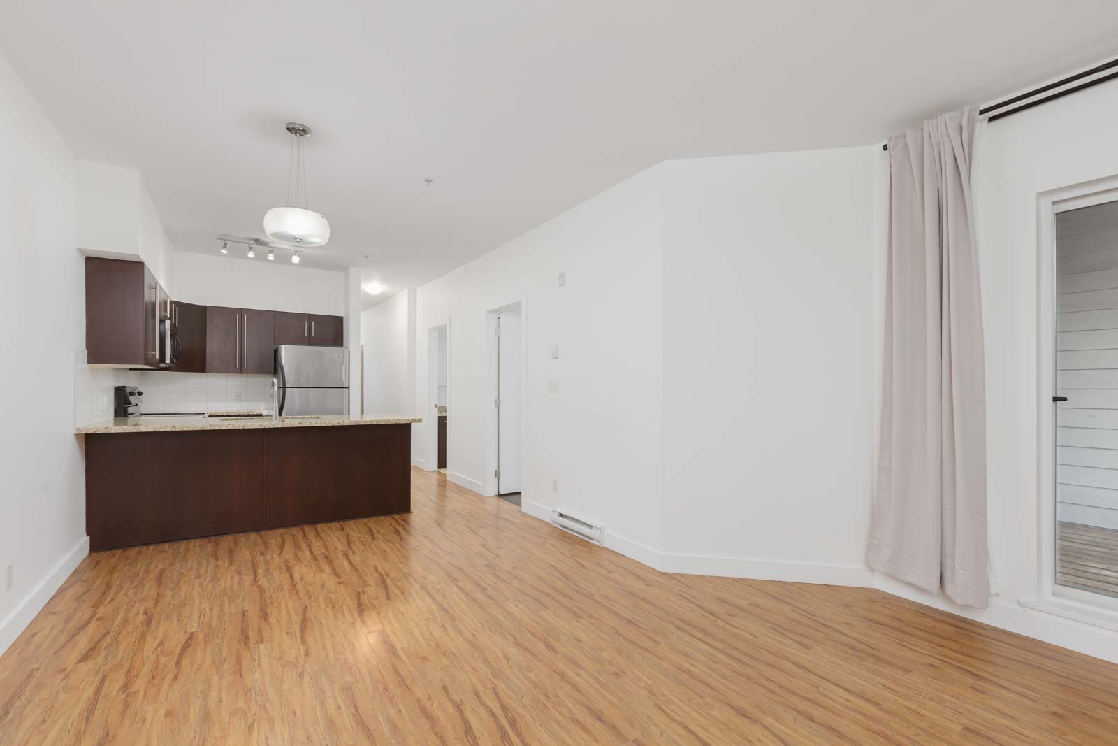living room in Burnaby condo with kitchen in background