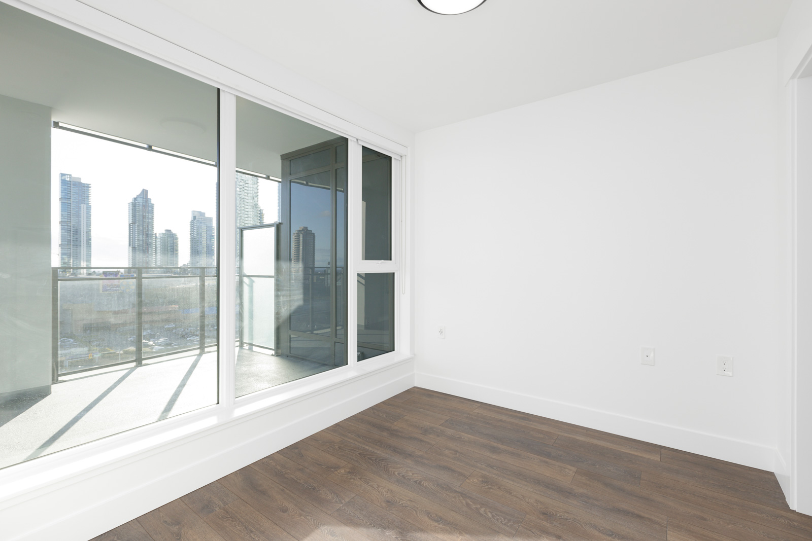 bedroom with white wall and with floor-to-ceiling windows
