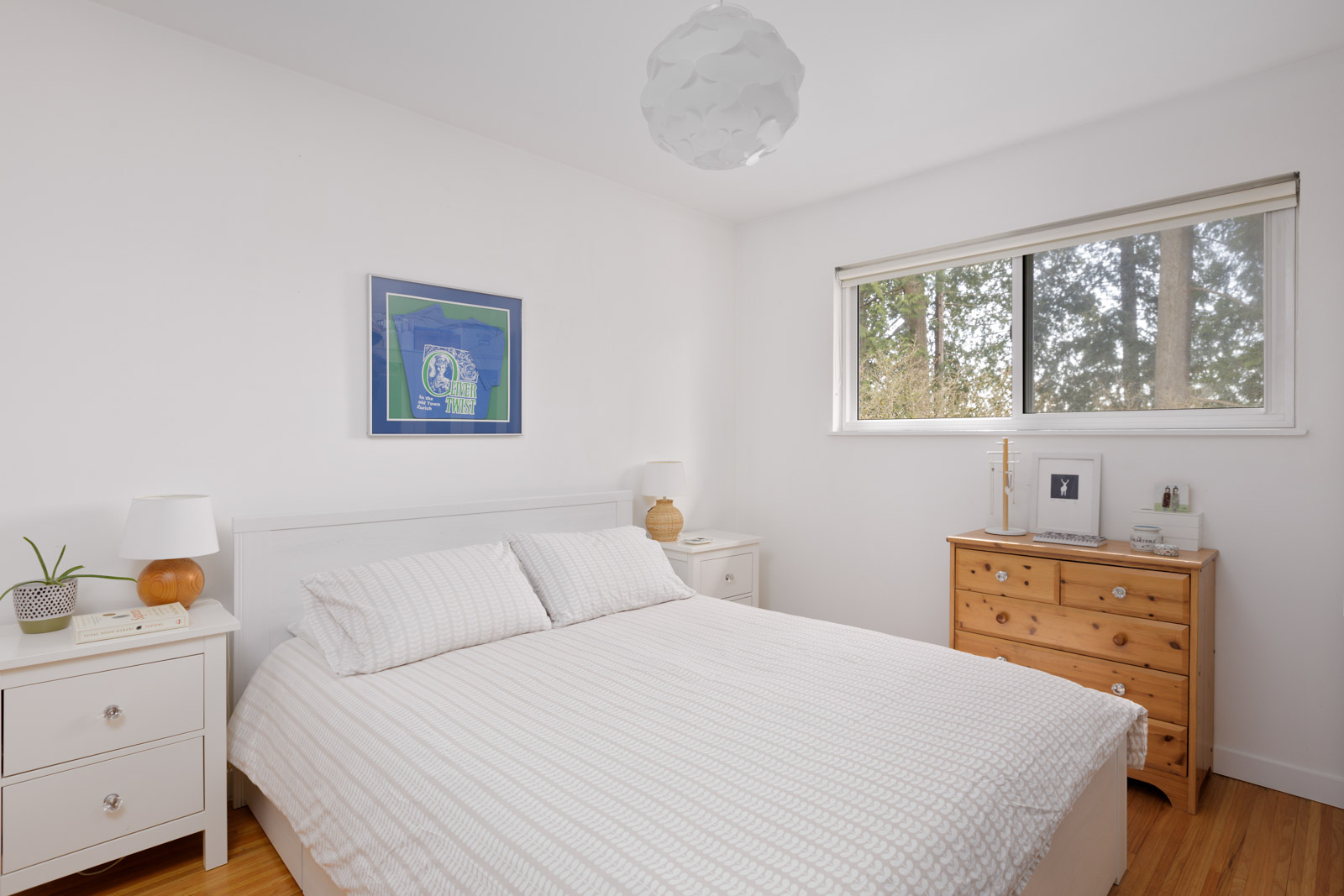 upper bedroom with window, white walls and hardwood flooring