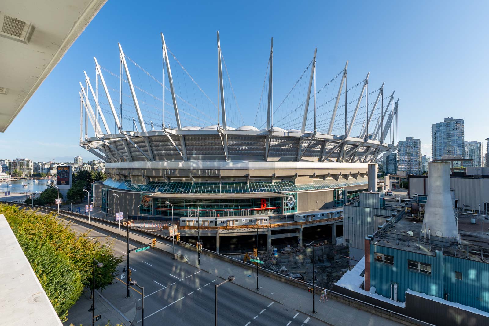 Exterior view of BC Place Stadium in Vancouver, with its distinctive roof and surrounding cityscape under a clear sky.