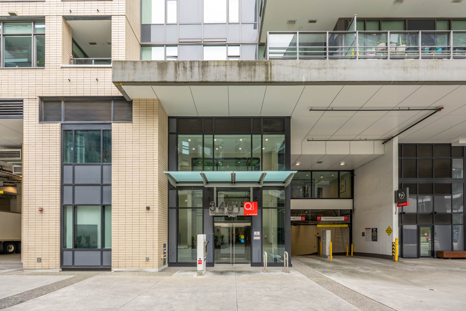 Street-level view of a modern building entrance with glass doors, labeled 