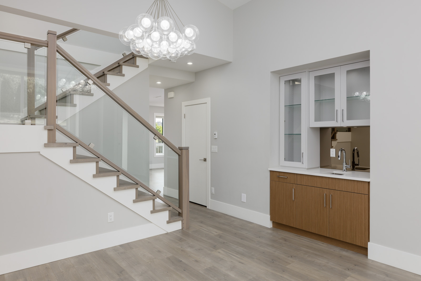 Entry foyer with bubble chandelier and wet bar in a Vancouver rental house managed by Birds Nest Properties