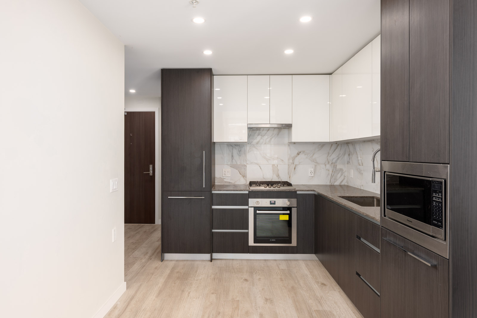 A kitchen with white cabinets and black appliances.